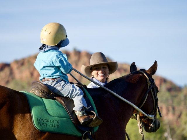 Boy and mom on horse in front of kelly's knob