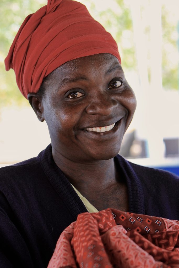 woman in pandamantenga botswana showcasing a hand-sewn quilt